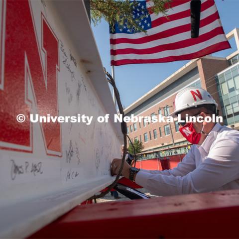 Chancellor Ronnie Green adds signatures to the last beam before it is placed. Due to COVID-19 precautions, a public ceremony was not able to be held. Instead, signatures from college and university supporters and others involved in the Phase I project were gathered either remotely or by signing the beam individually. The final beam was installed at the topping off ceremony for Engineering Project, August 26, 2020. Photo by Greg Nathan / University Communication.